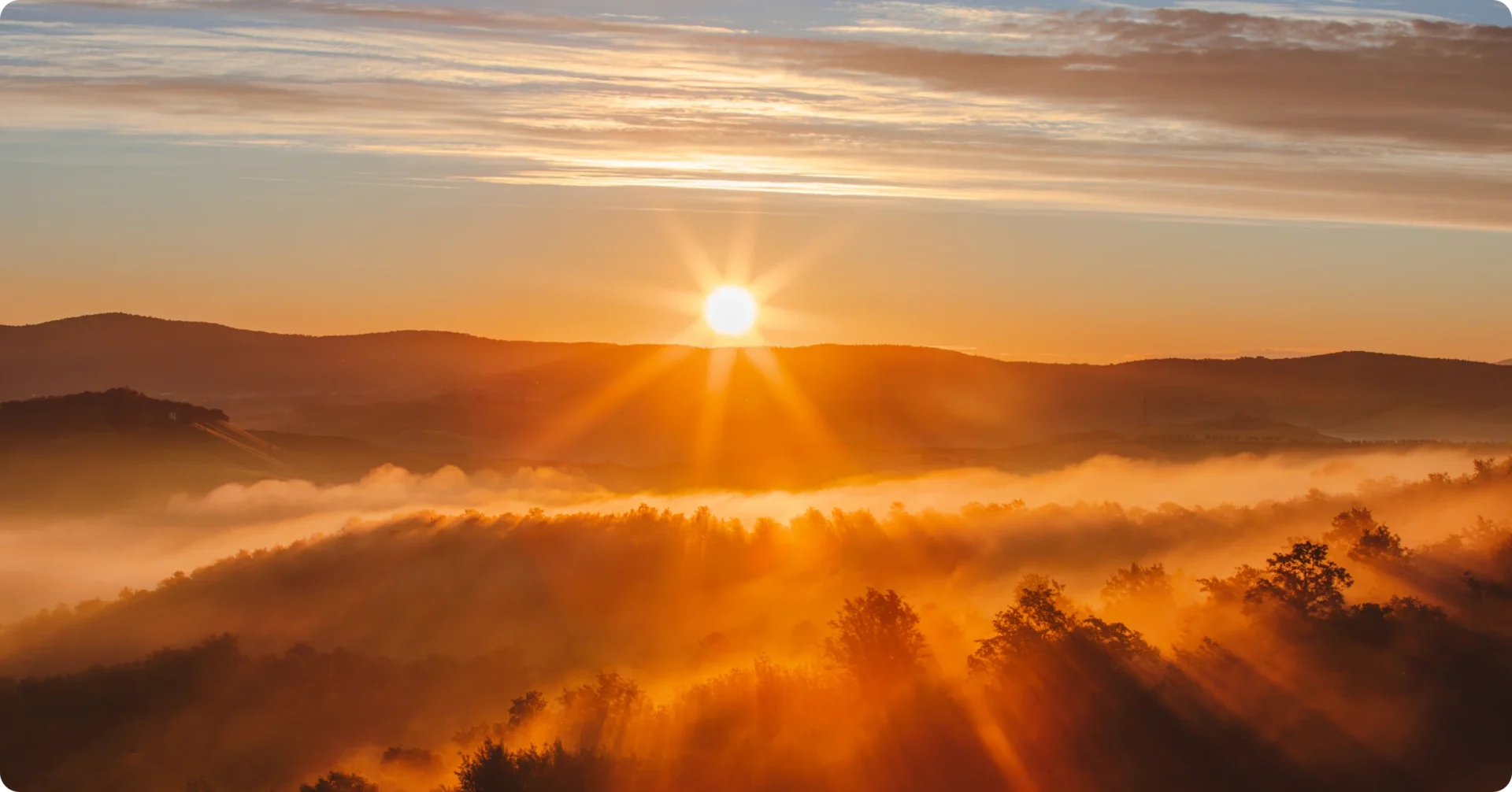 Morning sun illuminating foggy landscape