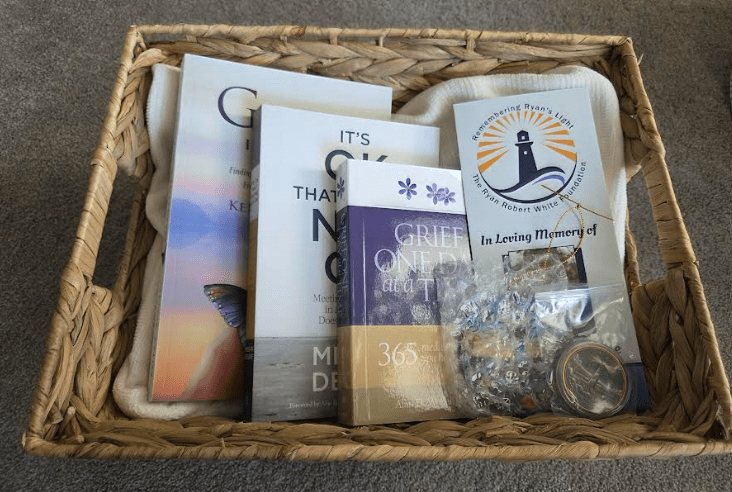A cozy gift box with books and a candle.